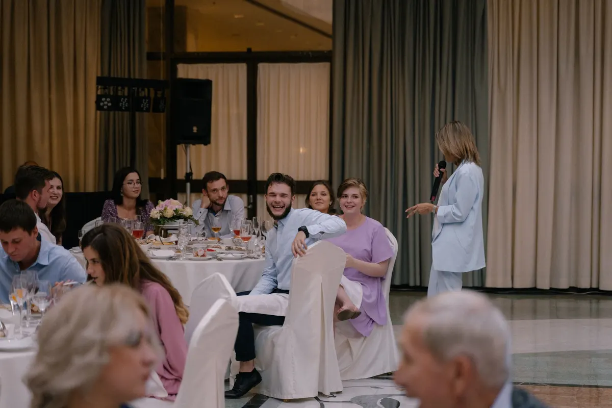 Guests at white-tablecloth tables listening to a speaker at a fundraising luncheon